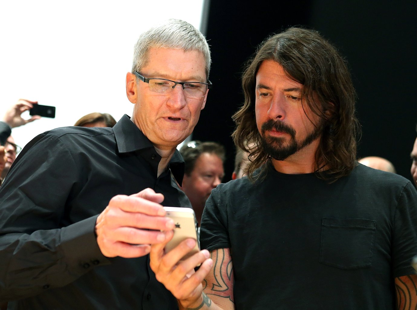 Apple CEO Tim Cook (L) and Dave Grohl of the Foo Fighters look at the new iPhone 5 during an Apple special event at the Yerba Buena Center for the Arts on September 12, 2012 in San Francisco, California. Apple announced the iPhone 5, the latest version of the popular smart phone. (Photo by Justin Sullivan/Getty Images)