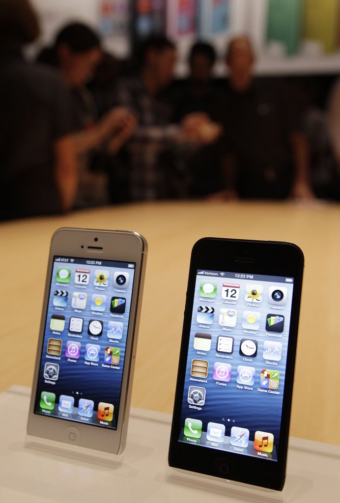 Media and guests look over the new Apple iPhone 5 on display following the introduction of new products in San Francisco, Wednesday, Sept. 12, 2012. (AP Photo/Eric Risberg)