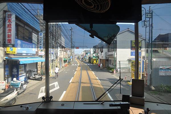 於馬路中央行駛的電車