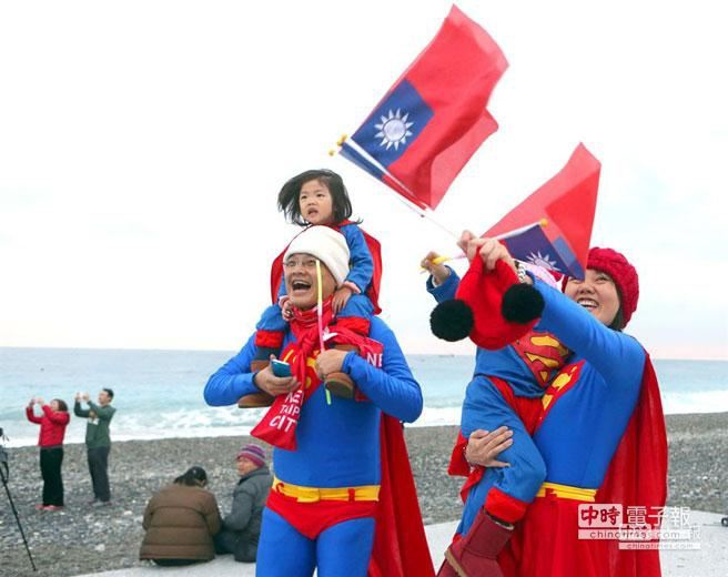 裝扮成超人家族的民眾拿著國旗開心，迎接2014年曙光。（王英豪攝）