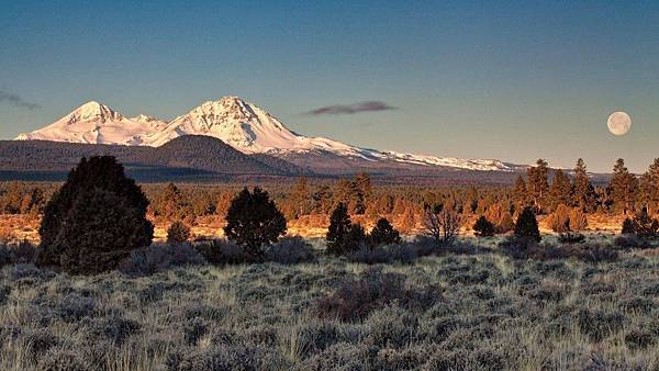 Sister-mountains-with-the-full-moon-setting-at-sunrise-west-of-Bend-Oregon-930x523.jpg