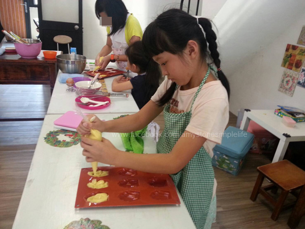 小孩穿上圍裙作蛋糕 小孩穿上圍裙作蛋糕