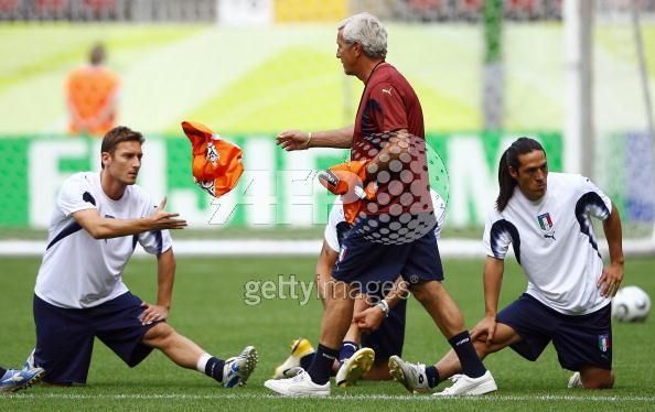 Italian coach Marcello Lippi (C) throws a bib to forward Francesco Totti (L) as midfielder Mauro Cam