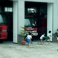 在消防車前玩一二三木頭人的孩子們