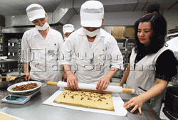 烘培班也能培養受刑人的一技之長。圖為北監受刑人正在製作即將量產的咖啡核桃蛋糕卷。 (攝影／林格立).gif