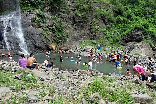 遊客嬉遊瀑布潭水