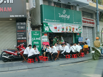 坐在路邊飲料店門口聊天的人們