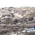 岳俊坐在一堆奇石中