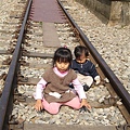 一雙娃兒坐在鐵道上