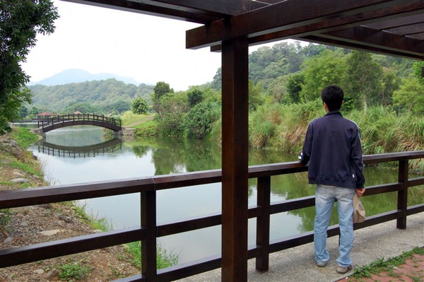 2009-06-06與永祥驅車前進桃園龍潭兜風逍遙，首站來到位於大漢溪畔的三坑自然生態公園。永祥立於公園的生態湖畔，欣賞木拱曲橋之美