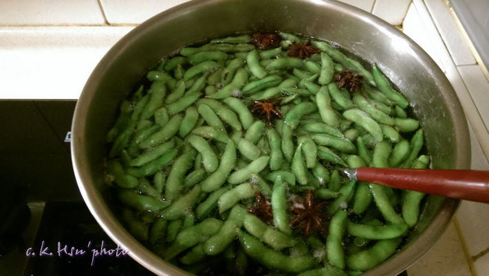 此時豆莢會漸漸由淺綠變翠綠色，以勺子邊煮邊勺毛豆，使其在水中上下調換，受熱均勻。