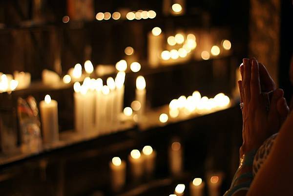 close-up-photograph-of-person-praying-in-front-lined-candles-1024900.jpg