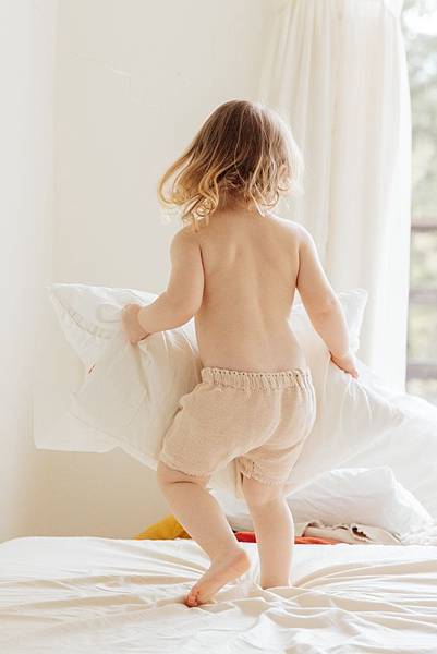 cute-little-girl-playing-with-pillows-on-bed-at-home-3933040