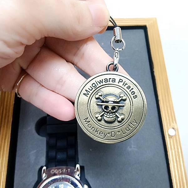 金色圓幣上面刻著《Mugiwara Pirates 》，下面刻著「Monkey.D.Luffy」蒙其·D·魯夫