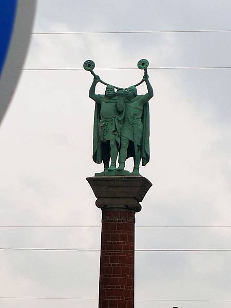 市政廳旁邊吹著奇怪樂器的銅像