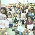 準備好了哩！孩子們高舉著自己的彩繪，等不及下一刻的造紙時間了！
