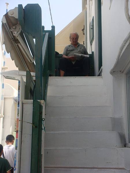 米克諾斯街上讀報的希臘老人