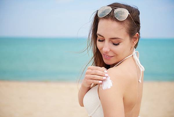 young-beautiful-woman-applying-sun-cream-beach