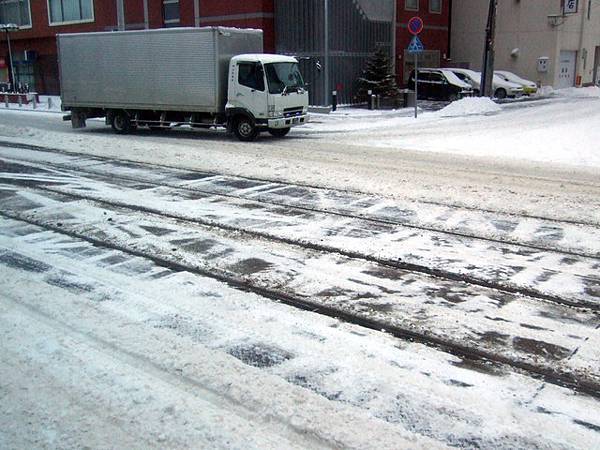 電車軌道和車道上的雪被壓得髒髒的