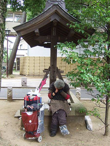 坐在參道附近休息的流浪怪婆婆，右腳套著塑膠袋