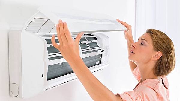 woman checking filters on air conditioner.jpg woman checking filters on air conditioner.jpg