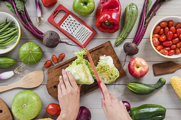 close-up-person-s-hand-cutting-cabbage-with-knife-chopping-board-surrounded-with-vegetables-table_23-2148165568.jpg