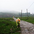 穿著雨衣走著泥濘路...