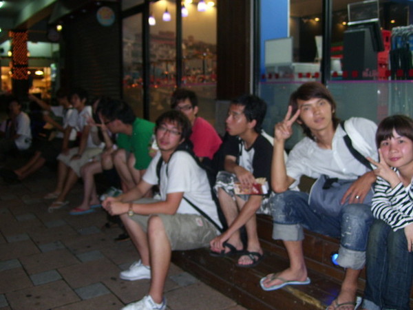 一群人坐在便利商店前