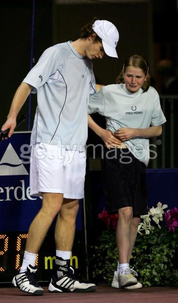 Andy Murray of Scotland helps a crying ball girl after she was hit off a serve from Greg Rusedski.jp