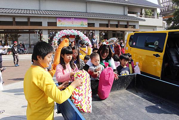 小朋友蜂擁而至將禮物搬上車.JPG