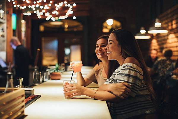 Women enjoying a specialty cocktail at a local restaurant_bar Chinatown