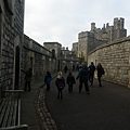 走在溫莎城堡(Windsor Castle)的城堡底下，早期的城堡為木質柵欄，後來已全部翻新為厚重石牆，左側這一排的石牆上都有個防禦作用的設計