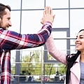 young-happy-man-woman-friends-giving-high-five-near-glass-building_23-2148192522.jpg