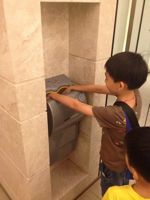 孩童洗手後，使用dyson airblade乾手機快速乾手，預防流感