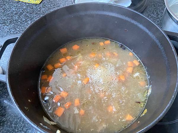 過濾熬好的湯汁，加入紅蘿蔔塊和切好的小肉塊