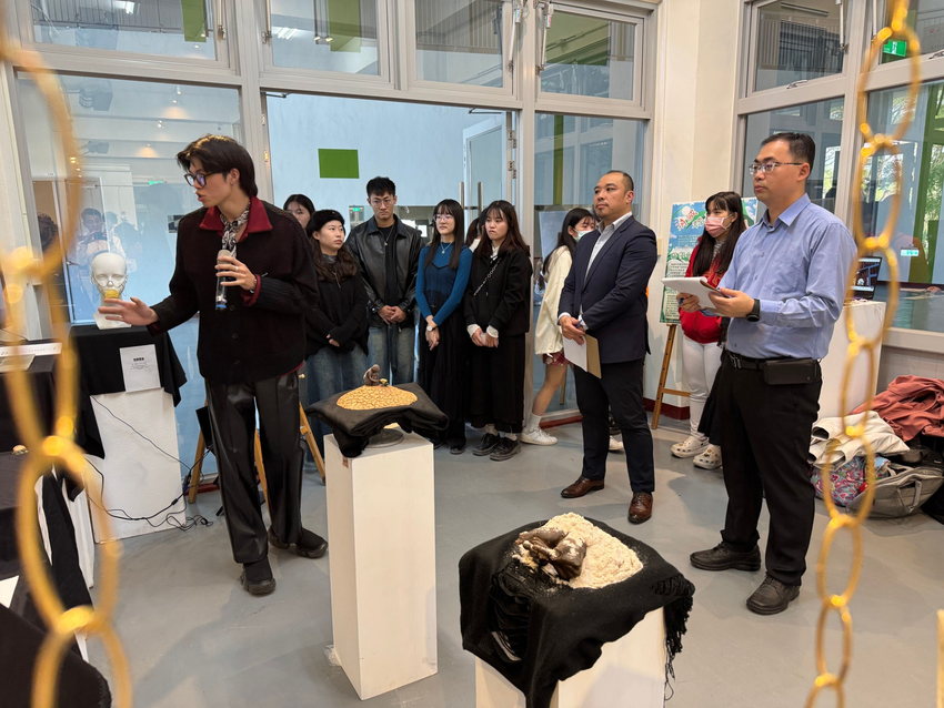 HTC新聞照-高雄大學藝創系學生向HTC台灣區業務總監簡瑞春（右二著西裝）及國立清華大學吳聲毅教授（右一著襯衫）介紹作品.png