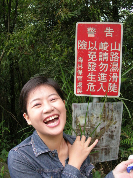在警告標語前的笑容