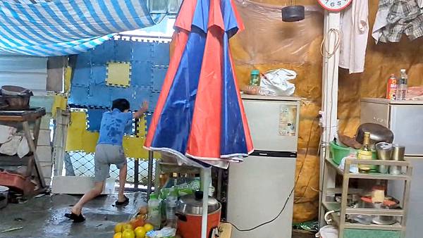 01阿志和外婆用地墊為脆弱的家擋住強風,展望會社工在風災稍緩後,立即前往關懷並提供生活支持補助。(台灣世界展望會提供) 01阿志和外婆用地墊為脆弱的家擋住強風,展望會社工在風災稍緩後,立即前往關懷並提供生活支持補助。(台灣世界展望會提供)