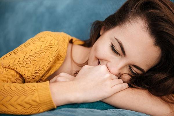 close-up-portrait-of-a-woman-lying-on-a-couch-PG4G82X.jpg