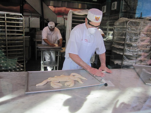 透過透明玻璃可以看到麵包師傅在做麵包