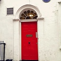 an azure name plaque beside a red door