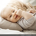 portrait-sweet-smiling-newborn-daughter-lying-cozy-bed-child-looks-camera-touching-face-with-her-little-hands-childhood-moments.jpg