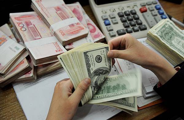 目前，中國經濟危如累卵。人民幣兌美元貶值成為中共兩會最熱門的話題之一，有香港專家認為，未來兩年人民幣還會繼續貶值。（STR/AFP/Getty Images）
