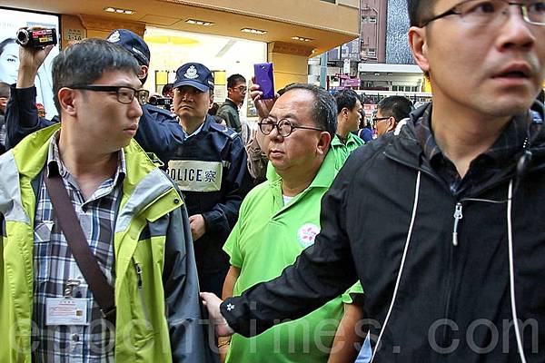 青關會副會長林國安被多名正義香港市民上前指罵，要靠多名警員保護。（潘在殊／大紀元）