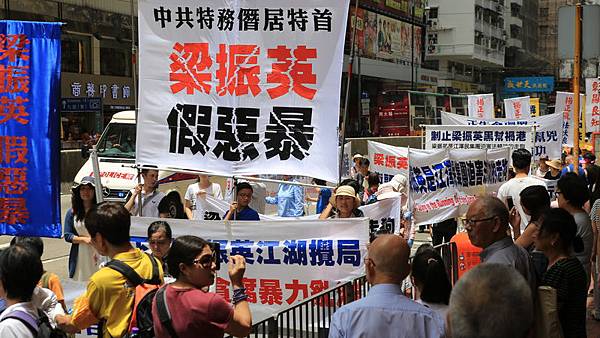 2014年7月1日，香港市民無懼恐嚇，紛紛走上街頭，用和平有秩序的方式，抗議中共亂港破壞一國兩制，要求特首梁振英下台。圖為參加遊行的民眾手持展板表達訴求。（余鋼／大紀元）