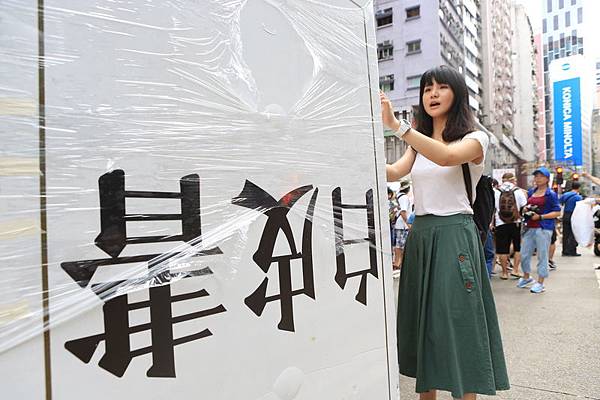 2014年7月1日，香港市民無懼恐嚇，紛紛走上街頭，用和平有秩序的方式，抗議中共亂港破壞一國兩制，要求特首梁振英下台。圖為參加遊行的民眾手持展板表達訴求。（余鋼／大紀元）