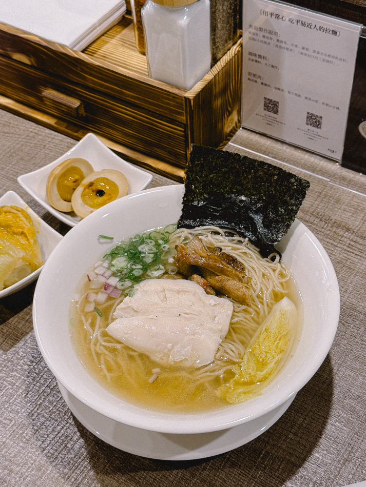 塩味拉麵特寫，呈現清澈湯頭、炙燒叉燒片、舒肥雞胸肉與蔬菜