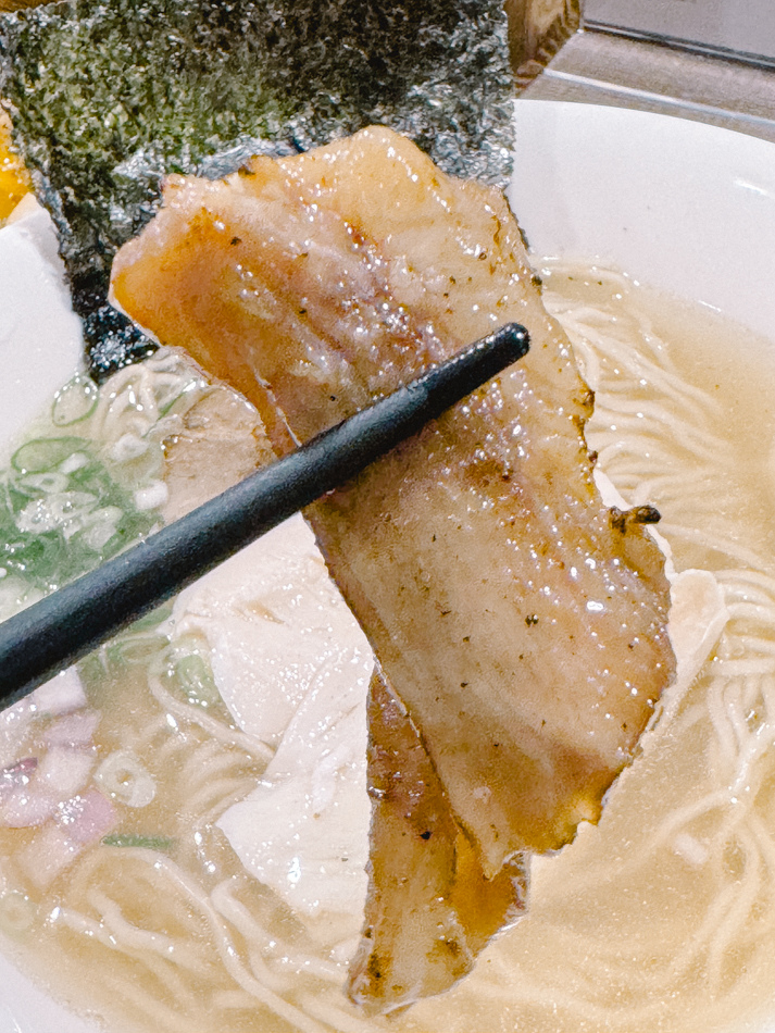拉麵配料特寫，顯示紫洋蔥圈、青蔥絲與舒肥雞胸肉