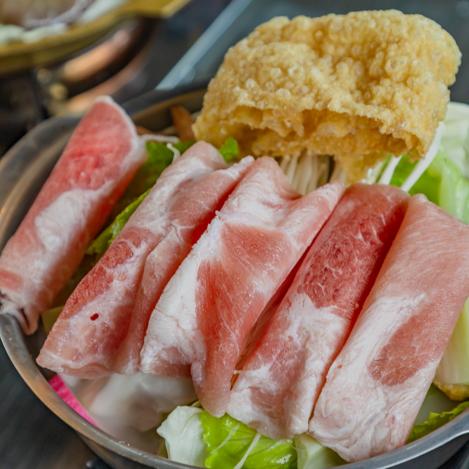龍骨白湯鍋湯頭透明乳白色與高麗菜、金針菇等配料特寫
