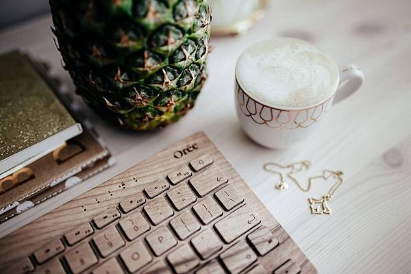 kaboompics_Wooden keyboard, cup of coffee, pineapple and golden jewellery.jpg